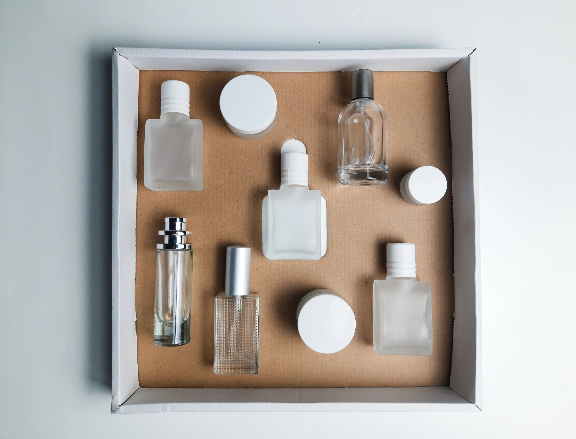 Designer and niche perfume bottles surrounded by sample vials